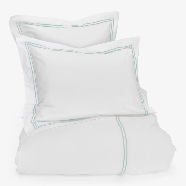 Clean and elegant white bedding set with mint piping accents