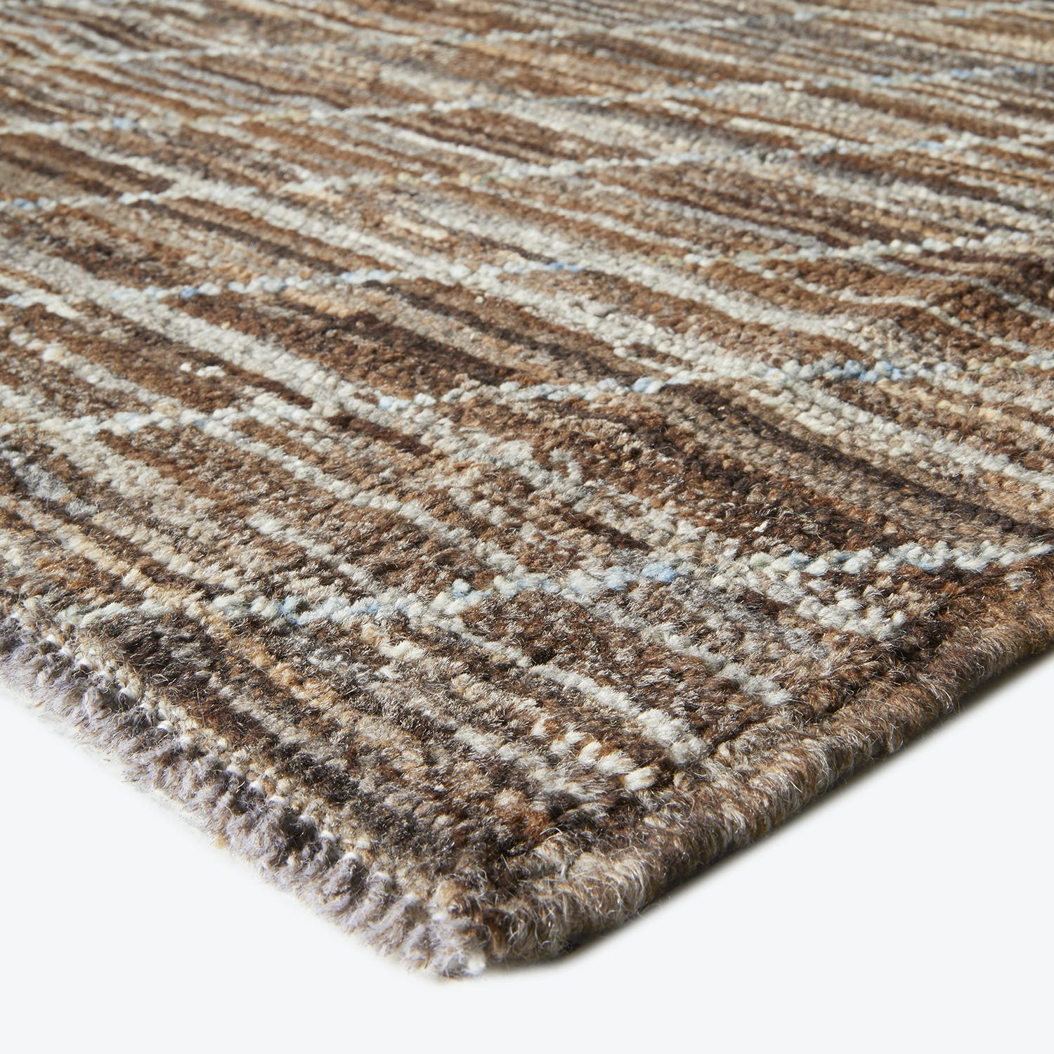 Close-up view of a plush striped rug with earthy tones.