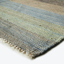 Striped woven rug with earthy tones and fringe details.
