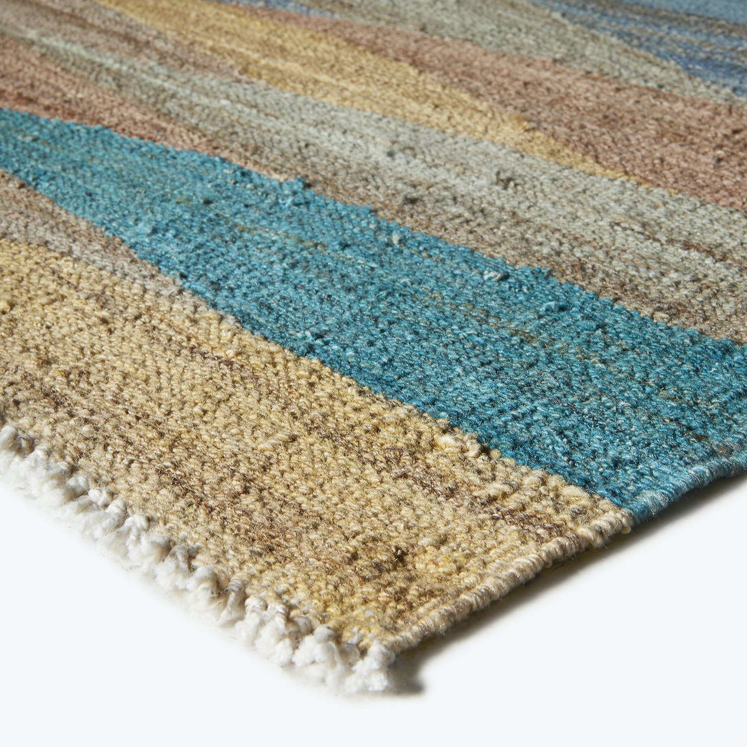 Close-up view of a colorful and textured striped rug with fringe.
