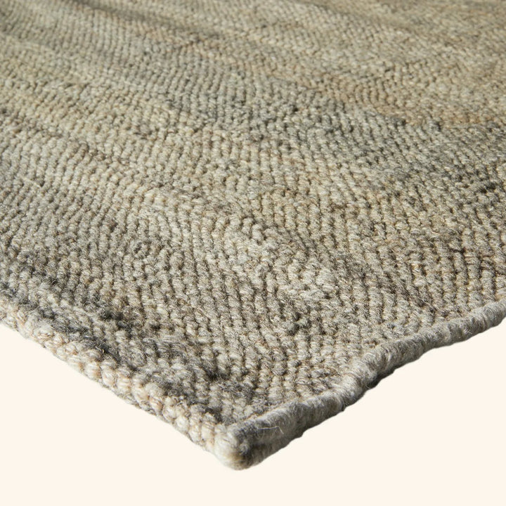 Close-up of tightly woven, textured rug in neutral shades.