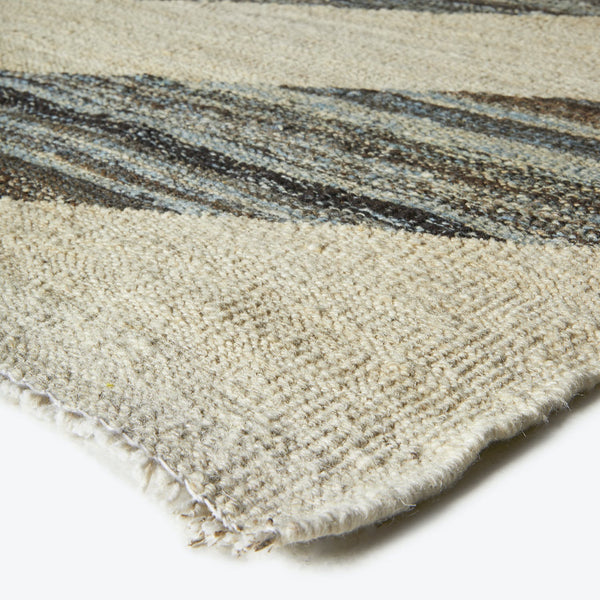 Close-up view of a well-used, textured rug with frayed edges.