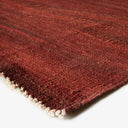 Close-up of a cozy, handcrafted rug with rich reddish-brown tones.