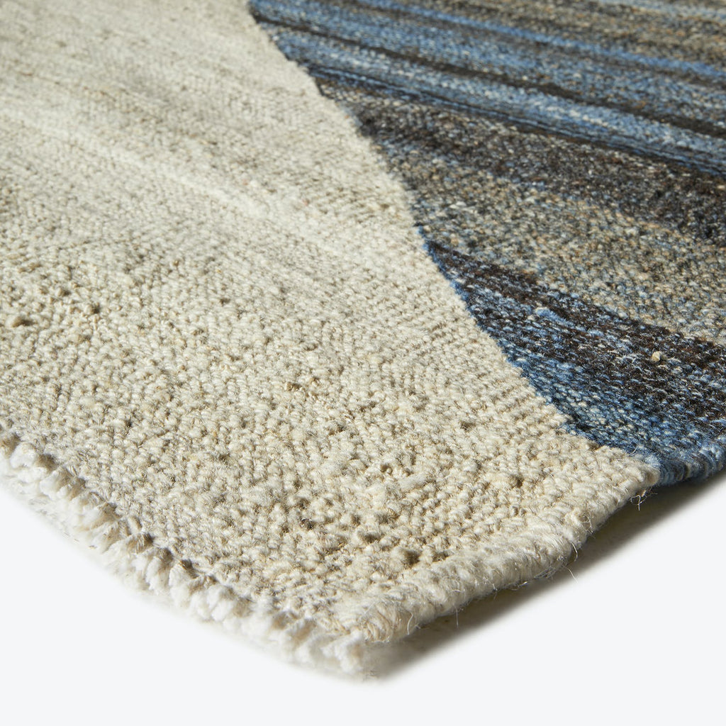 Close-up of a plush, gradient rug with finished binding.