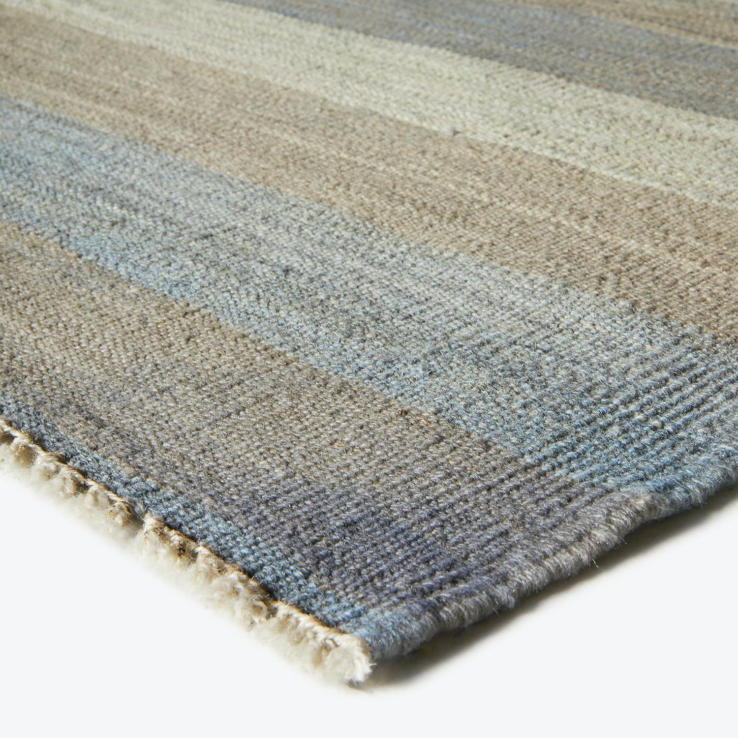 Close-up of a striped, textured rug with shades of blue.