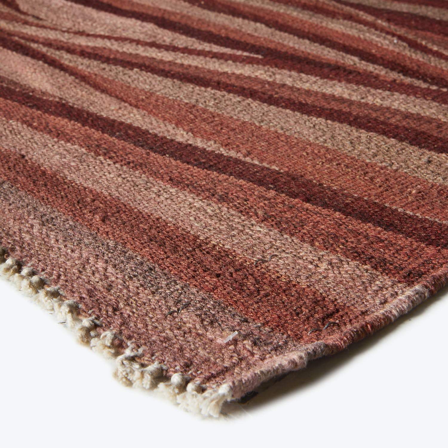 Woolen striped rug with fringed edge showcasing varied brown hues.
