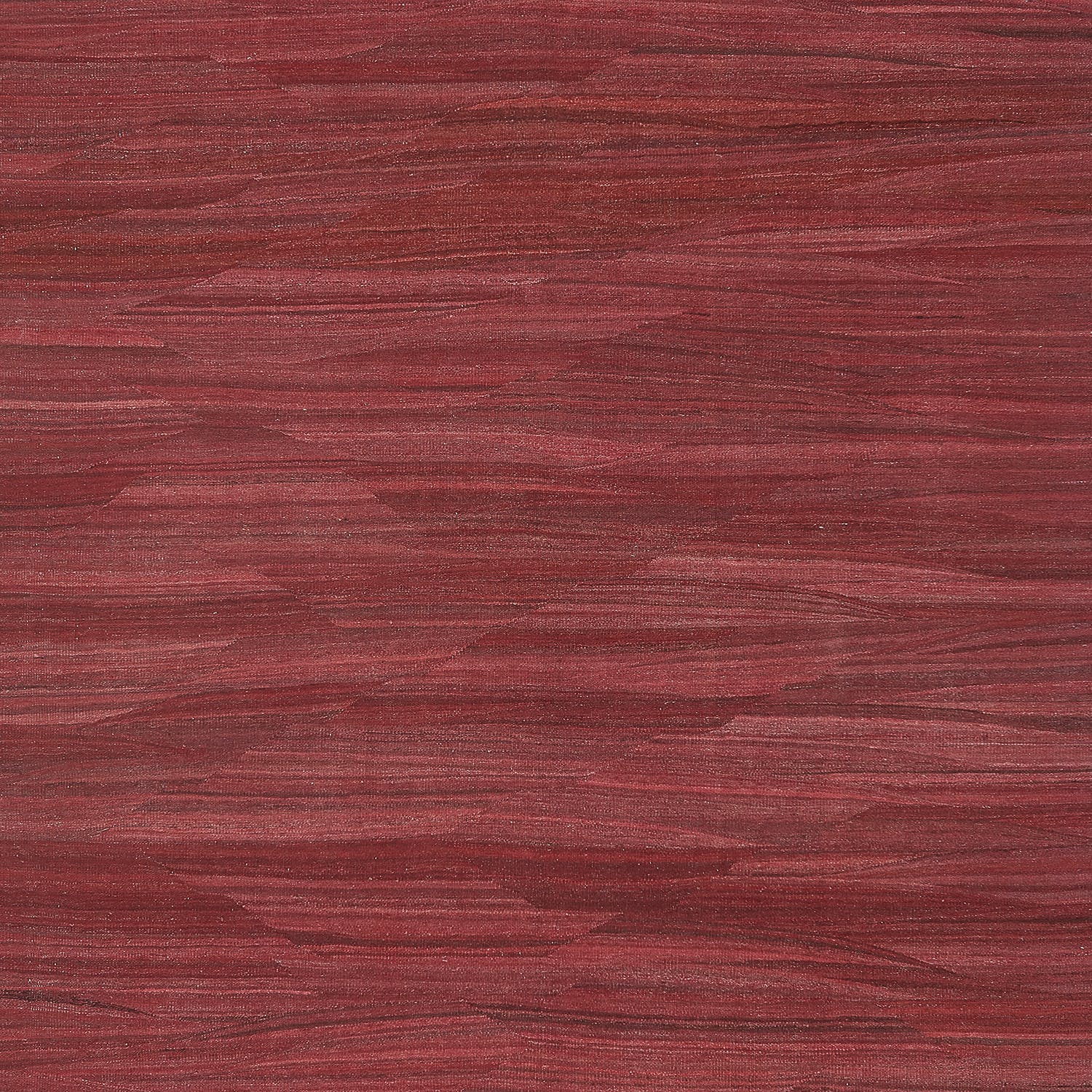 A close-up of a red wooden surface with distinct grain pattern.