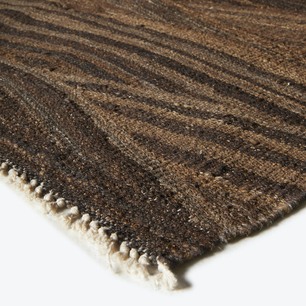 Close-up of a luxurious striped rug with rich earthy tones.