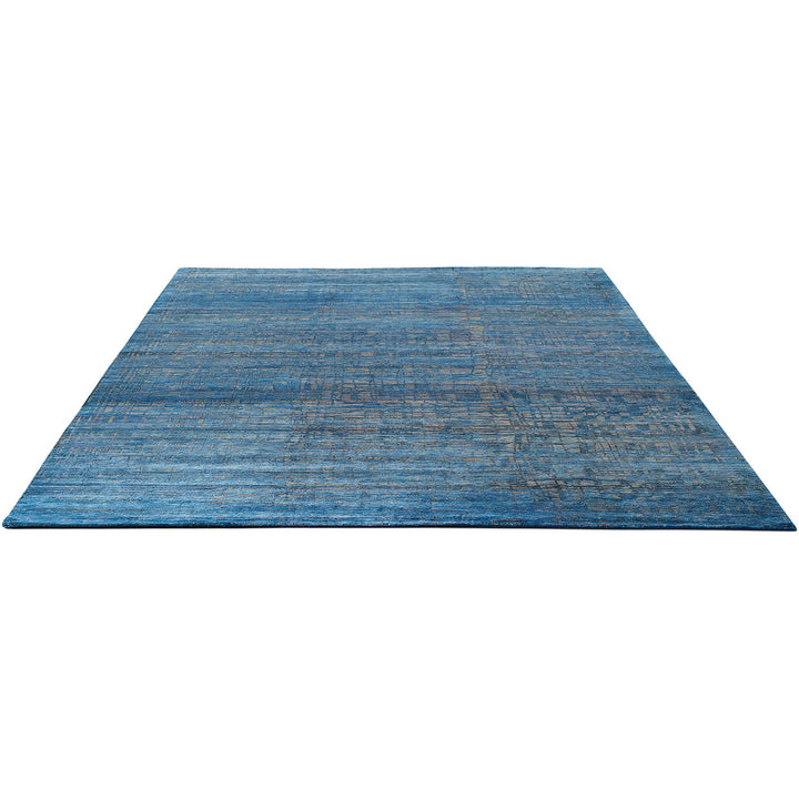 Blue rectangular rug with textured pattern and distressed, aged look.