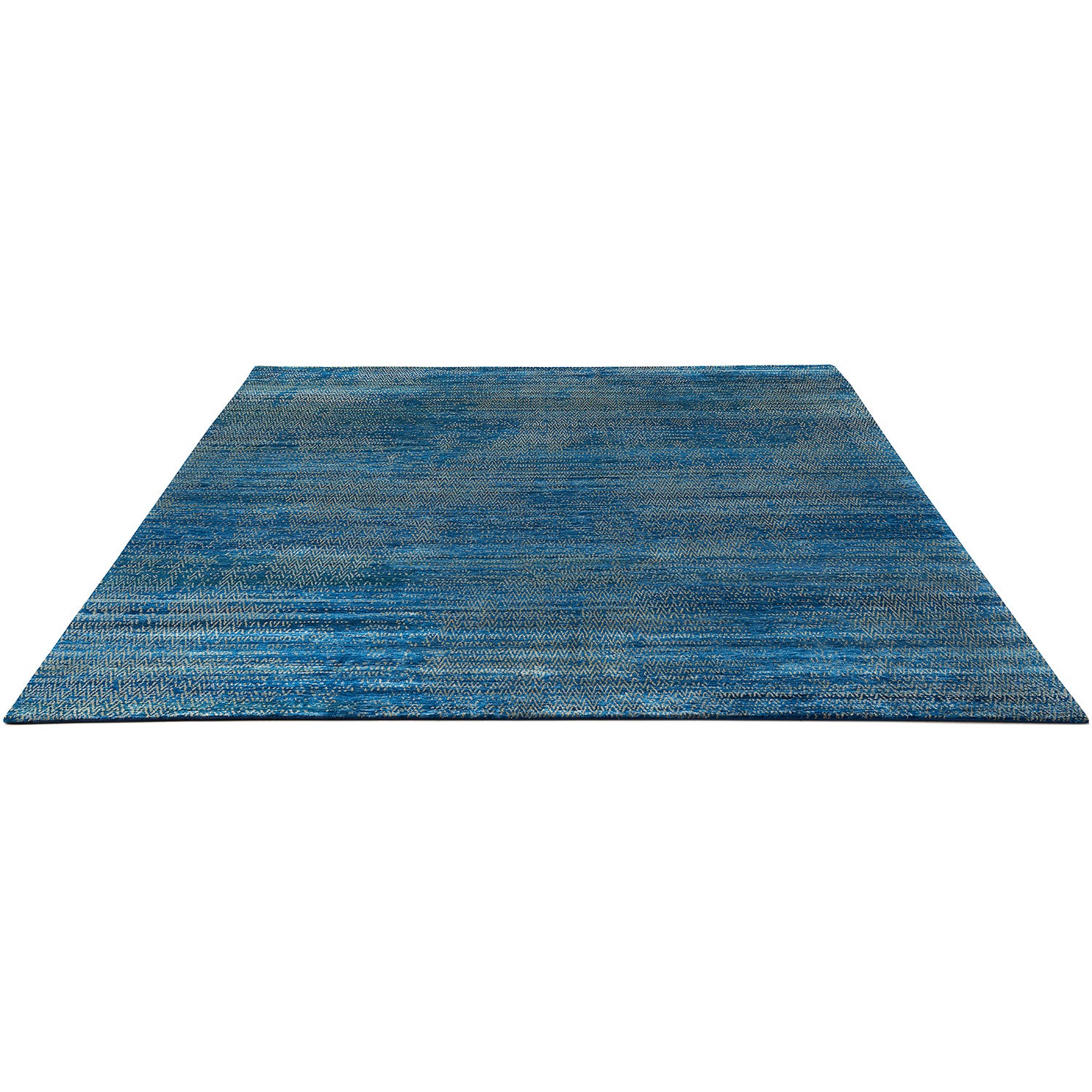 Close-up of a textured blue rug with varying shades and patterns.