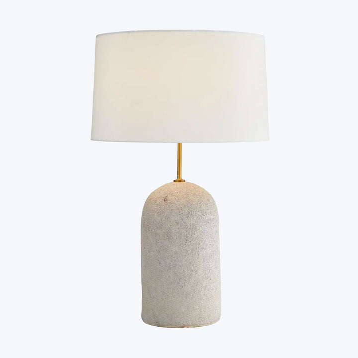 Contemporary table lamp with textured stone base and soft lighting.