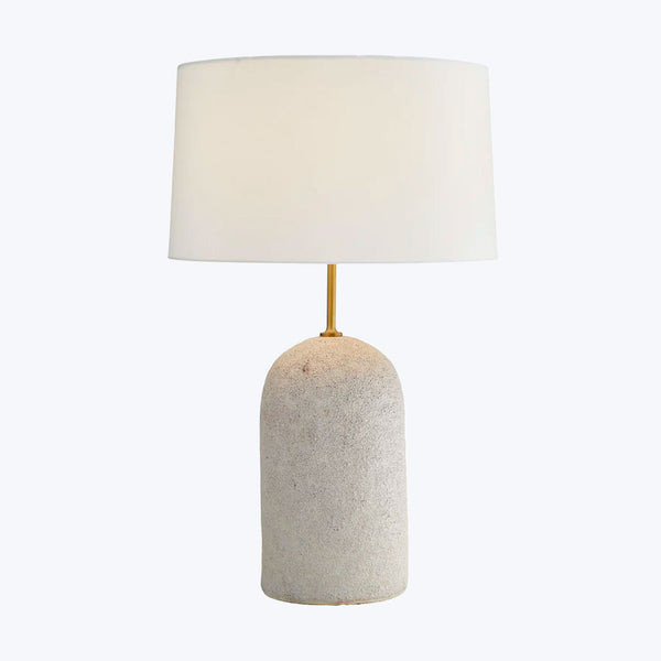 Contemporary table lamp with textured stone base and soft lighting.