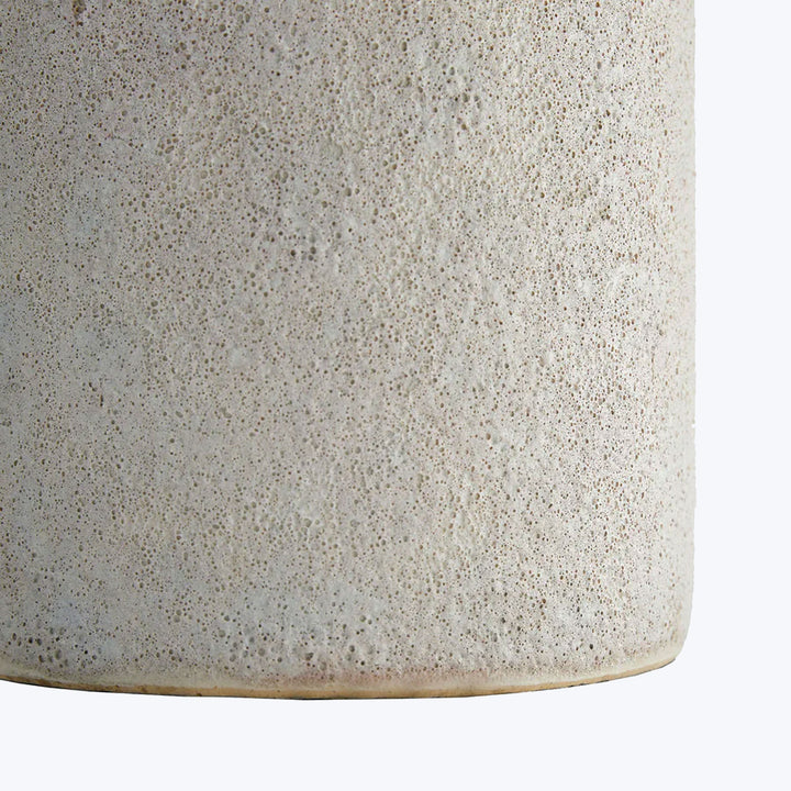 Close-up of speckled ceramic vase, off-white with brown flecks.