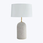 Contemporary table lamp with concrete-like base and minimalist design.