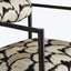 Close-up of a black metal chair with textured frame and abstract patterned upholstery.