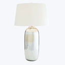 Modern table lamp with reflective base and cone-shaped off-white shade.