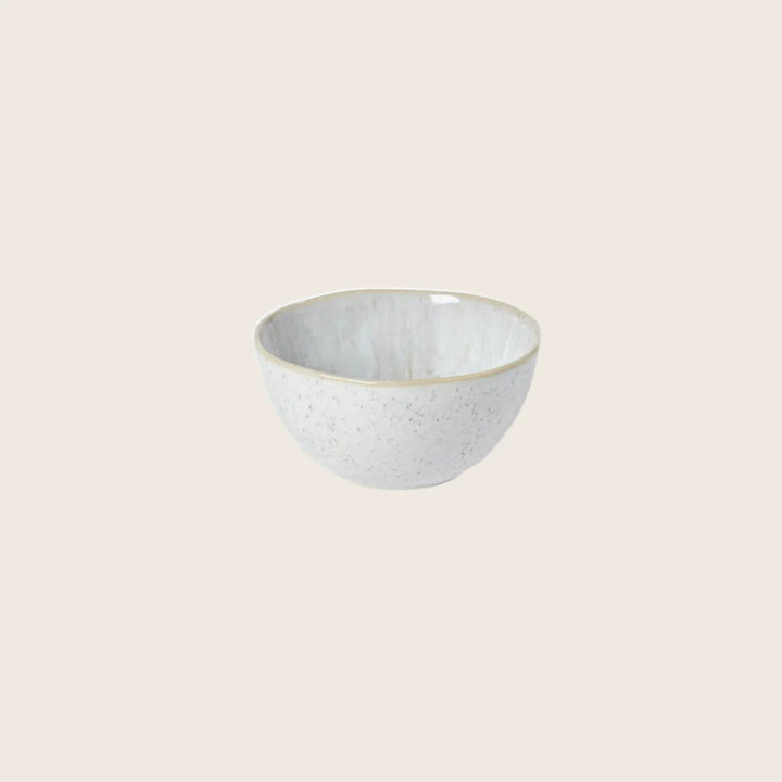 Handcrafted ceramic bowl with speckled finish, perfect for serving food.