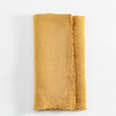 Folded yellow cloth with soft texture on white backdrop.