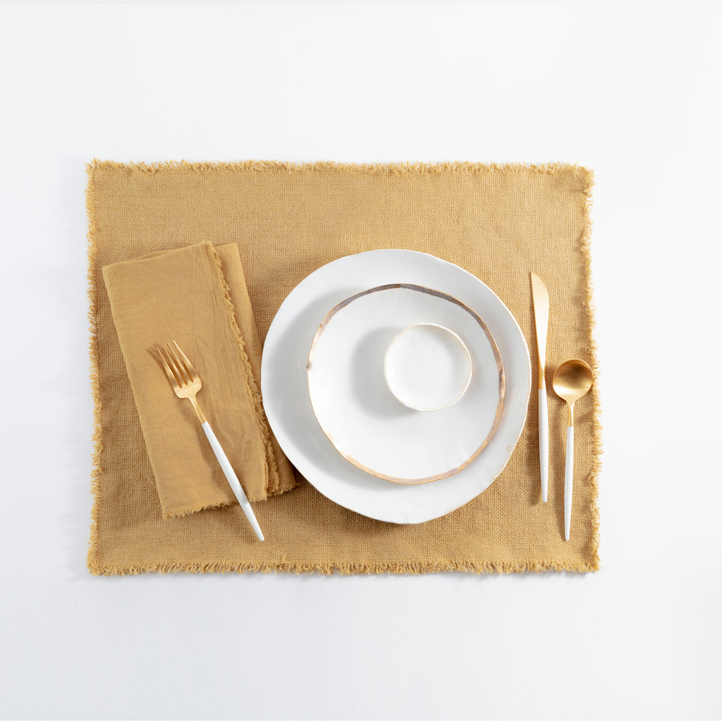 Elegant and rustic table setting with gold accents on white background.