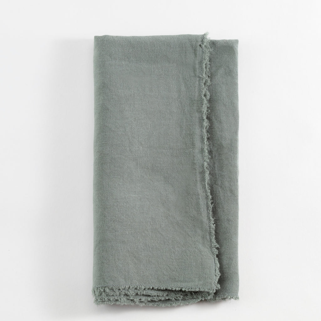 Frayed linen cloth in muted green or gray with rustic charm.