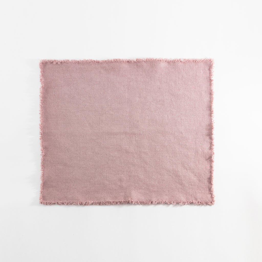 Light pink fabric with frayed edges, textured surface, no prints.