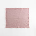 Light pink fabric with frayed edges, textured surface, no prints.