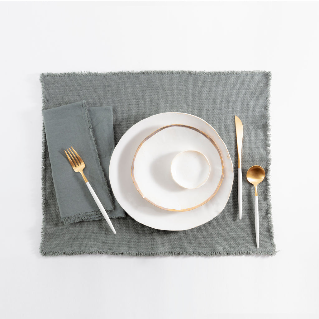 Neatly arranged table setting with white and gold cutlery.