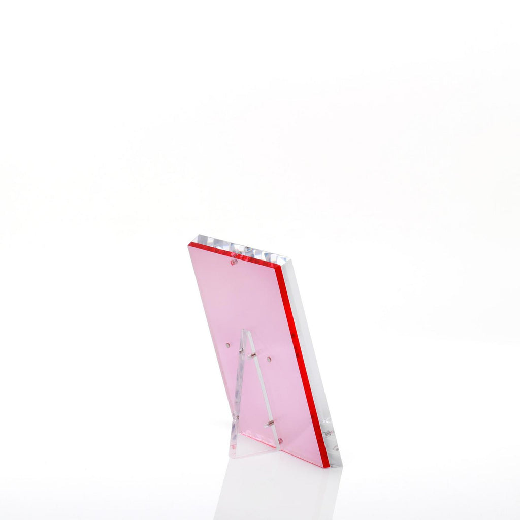 Transparent pink plaque with a beveled edge stands on display.