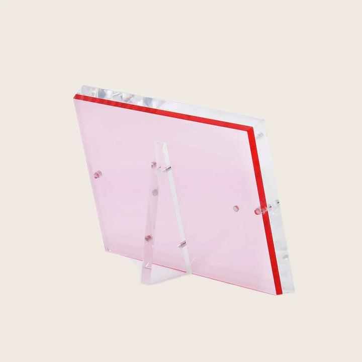 Sleek pink acrylic panel with vibrant red border and stand.