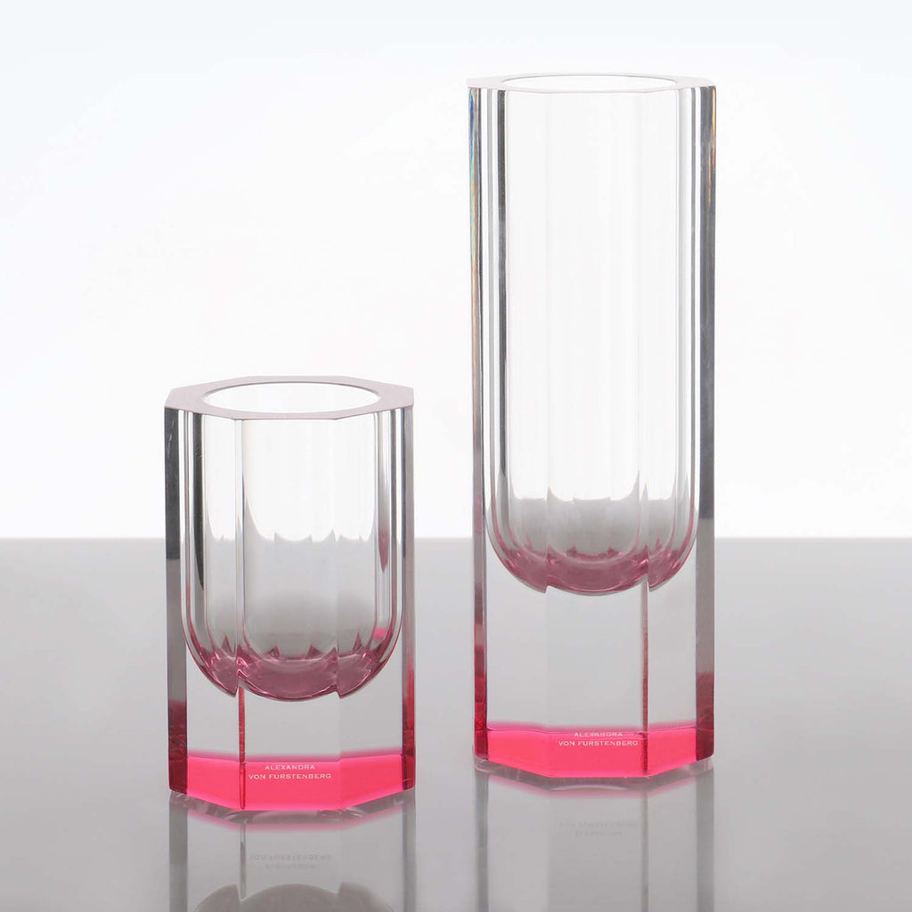 Two minimalist glass vases with pink bases add a pop of color.