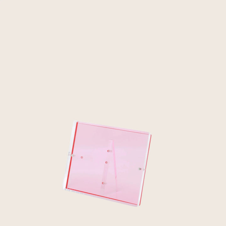 Transparent pink acrylic display stand against a clean white backdrop.