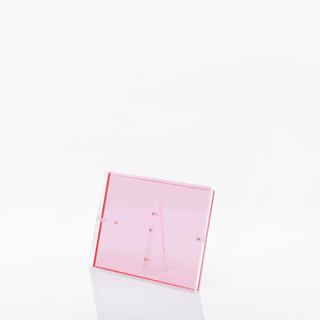 Transparent pink acrylic display stand against a clean white backdrop.