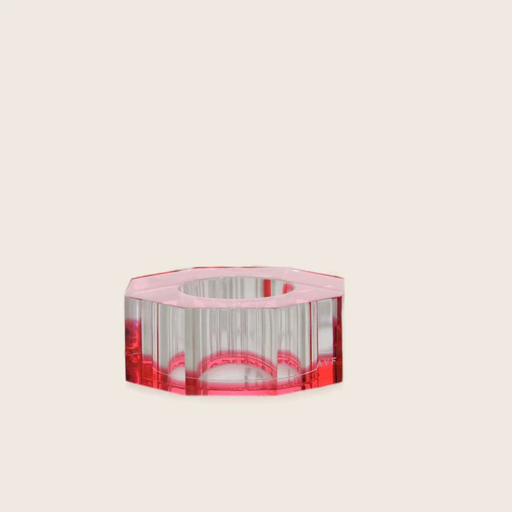 Transparent cylindrical objects with pink-red hue reflect light on surface.