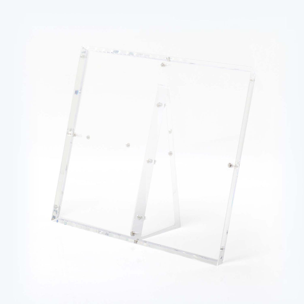 Minimalist and modern clear acrylic easel against a white background.