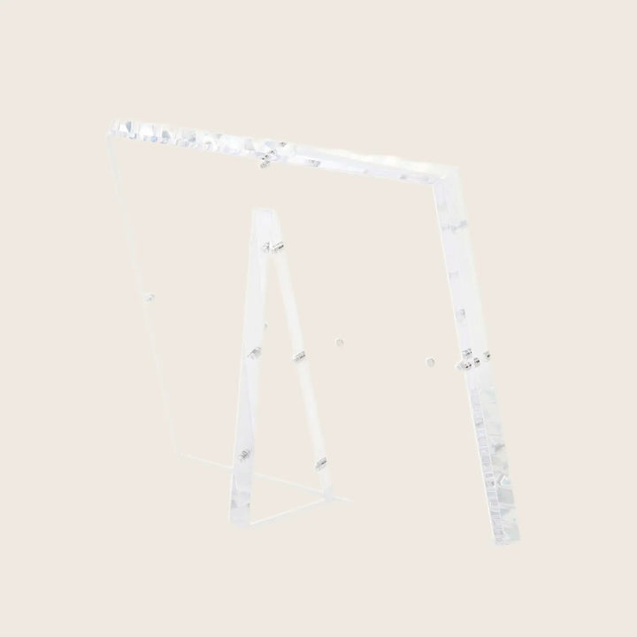 Modern, transparent A-shaped easel with minimalist design showcases artwork.