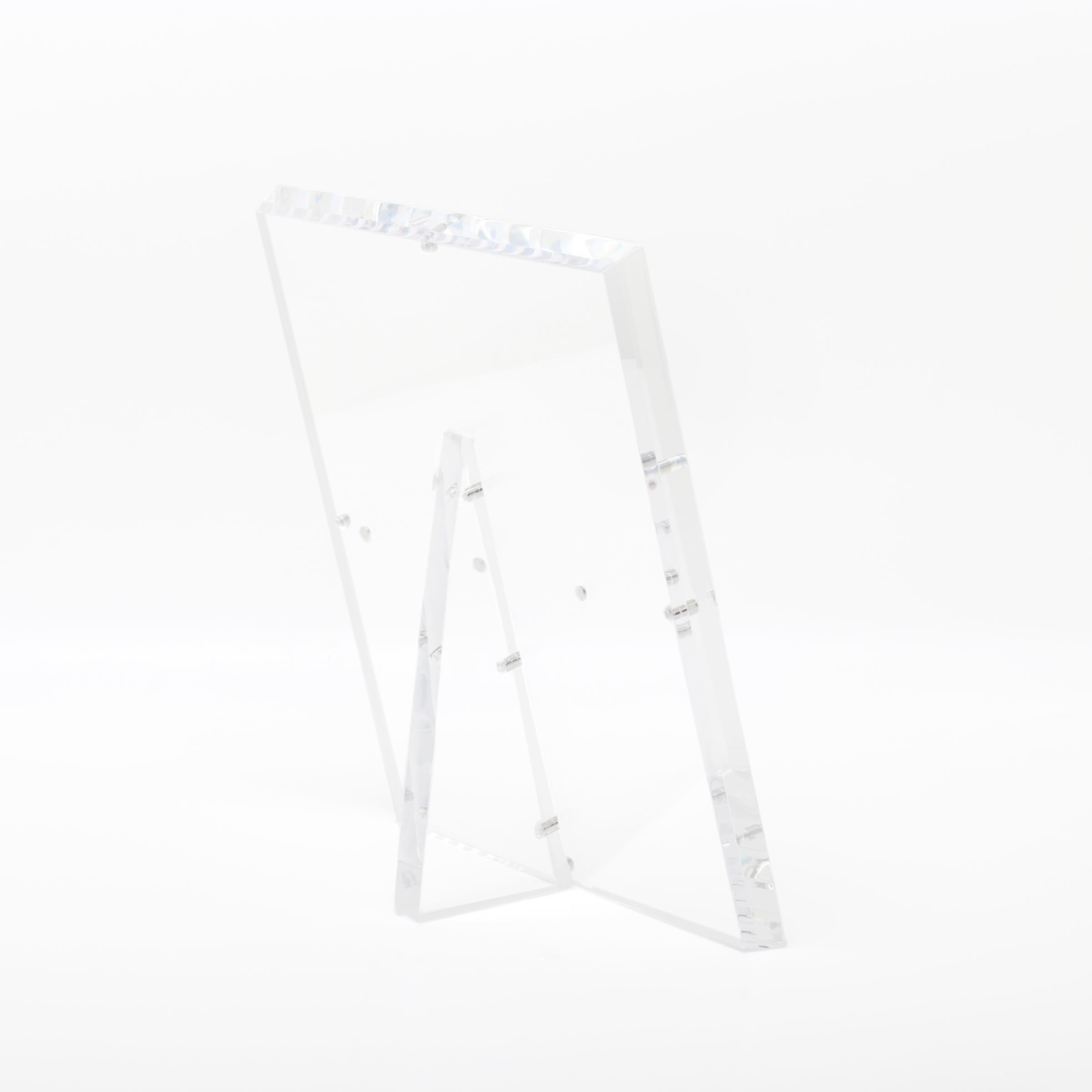 Minimalistic acrylic easel with raised edge for secure display.