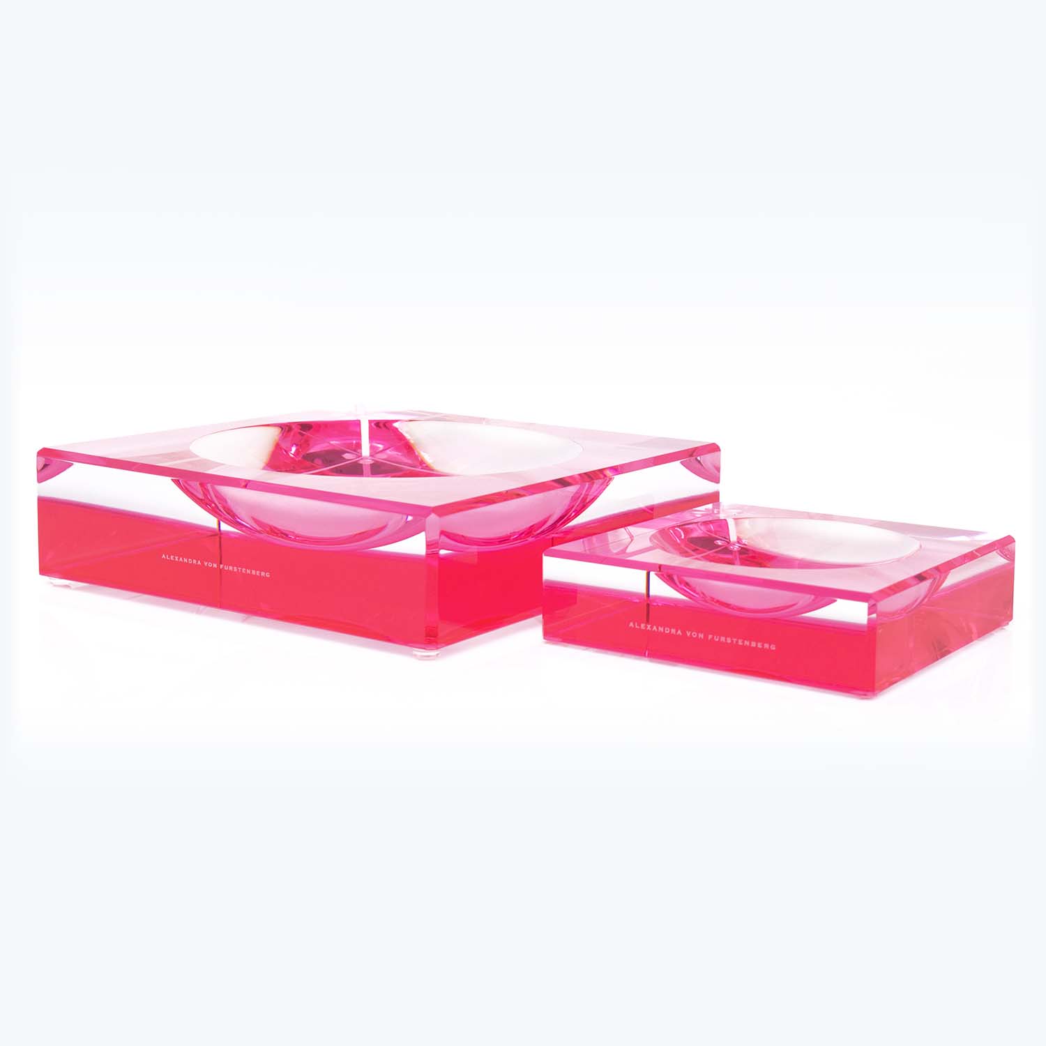 Two transparent pink acrylic boxes with circular depressions on top.