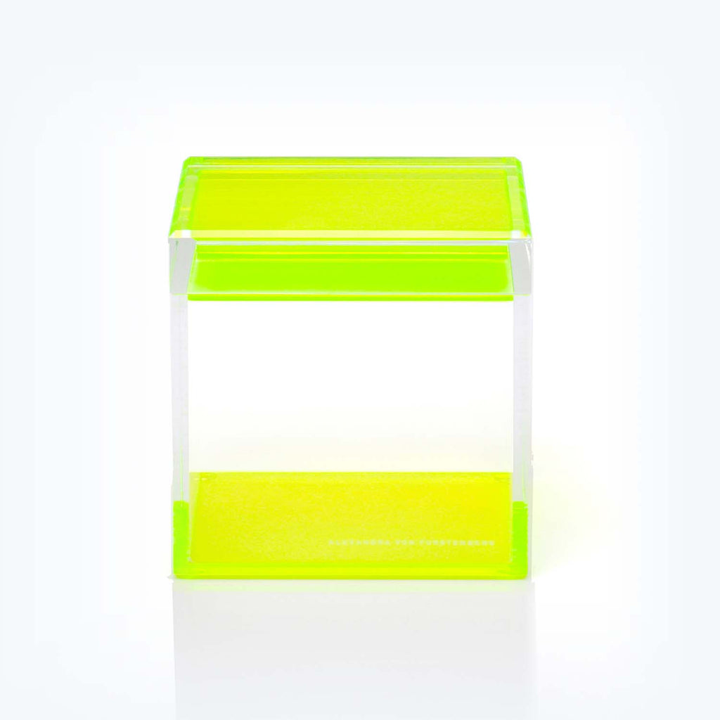 Vibrant neon green acrylic riser creates eye-catching display platform.