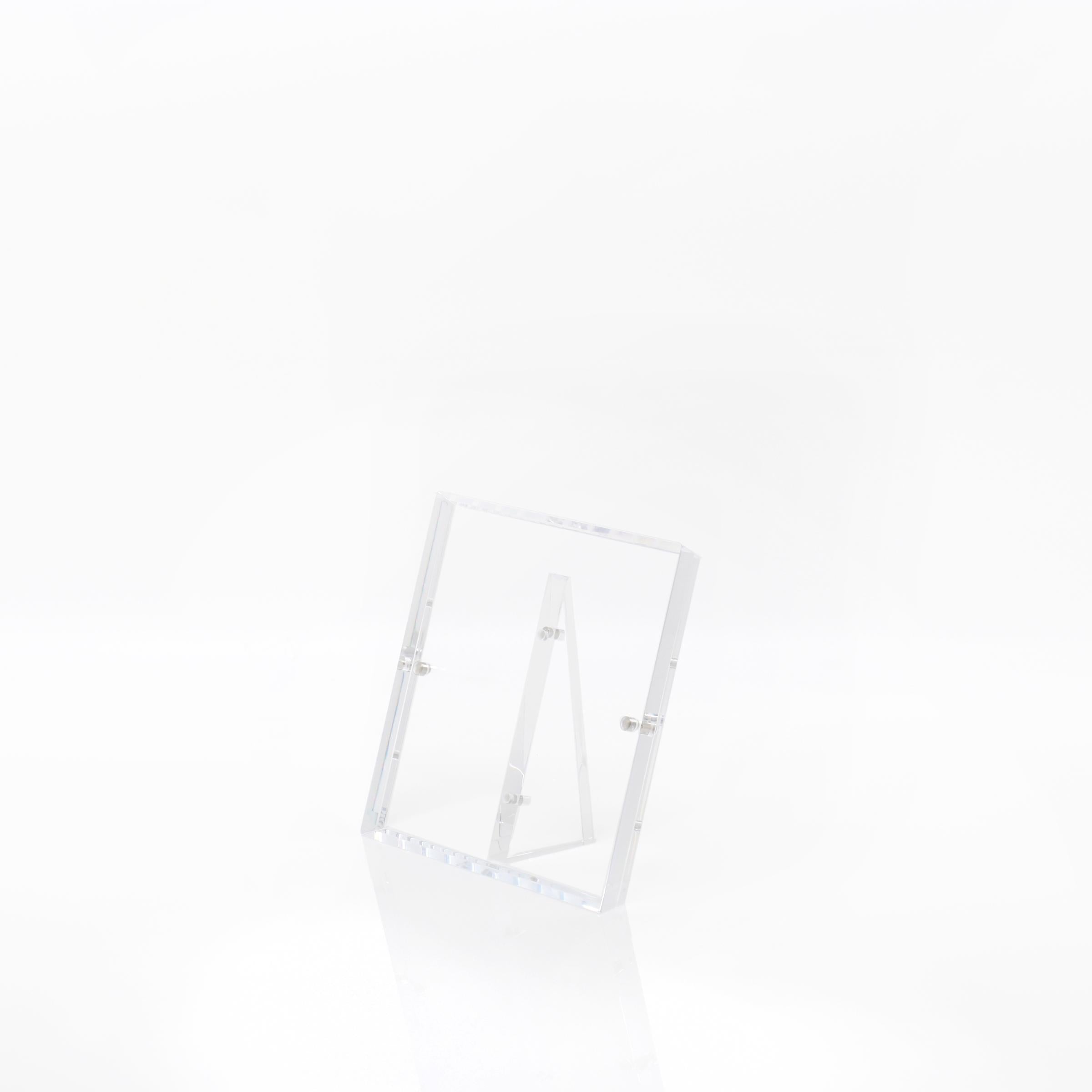 Minimalistic double-sided photo frame with transparent acrylic design and stand.