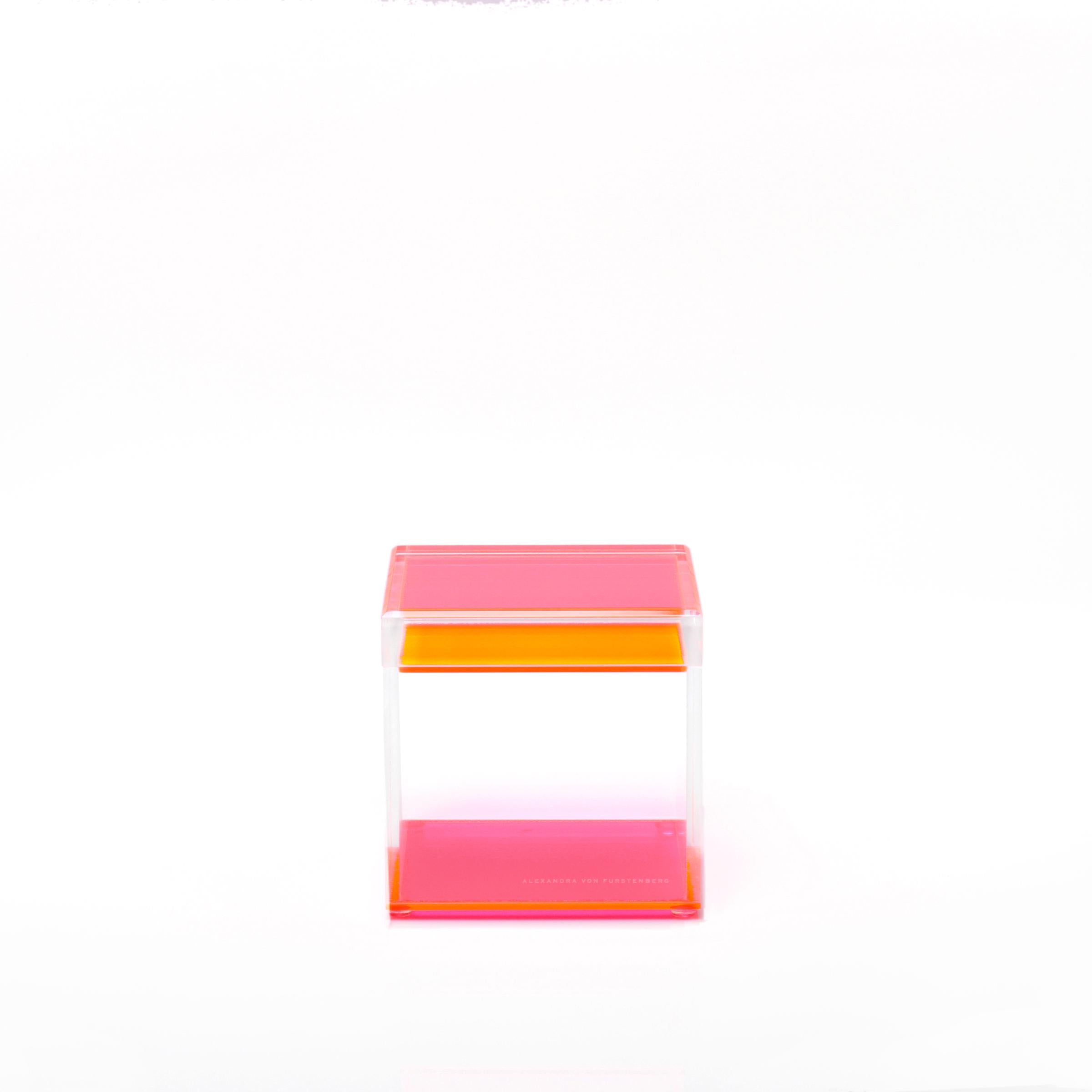 Minimalist acrylic chair with pink and orange accents on white background.