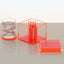 Minimalistic orange-themed items: glass tumbler with ice and open cigarette box.