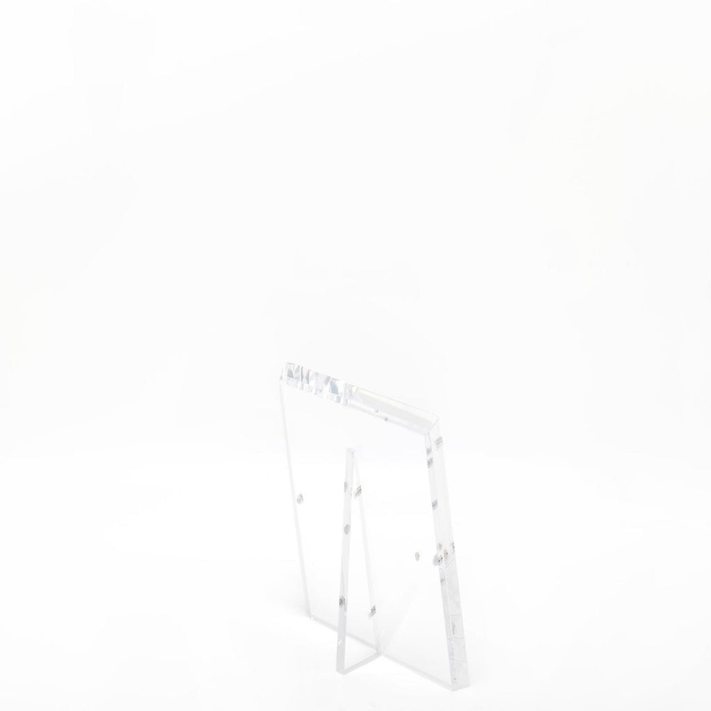 Minimalist clear acrylic stand with slanted legs for displaying items.