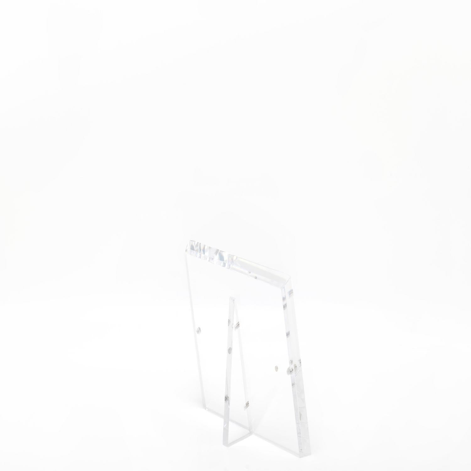 Minimalist clear acrylic stand with slanted legs for displaying items.