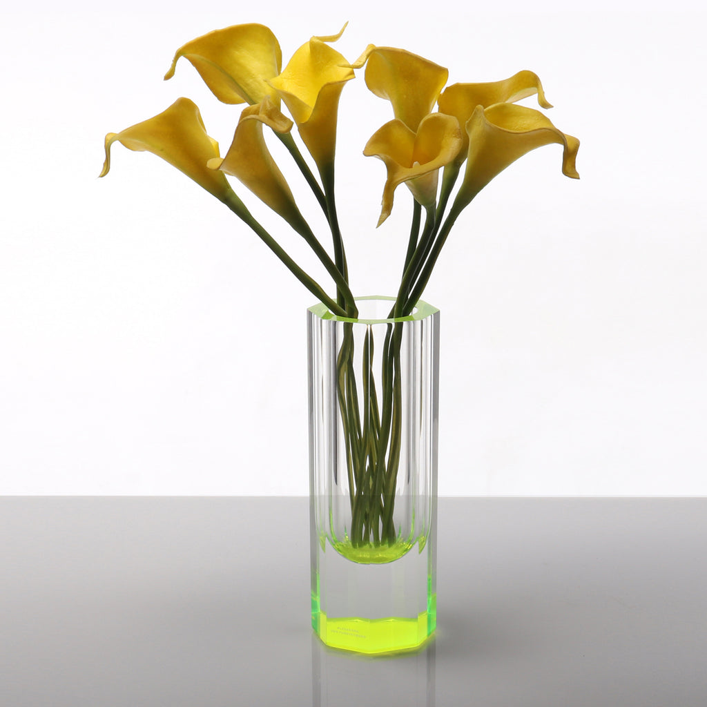 A vibrant display of yellow calla lilies in a modern vase.