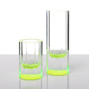 Two modern cylindrical glass vessels with a vibrant green glow.