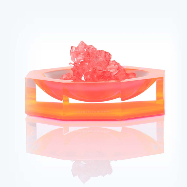 Translucent orange-tinted decorative object with pink crystal-like structures, by Diane von Furstenberg.
