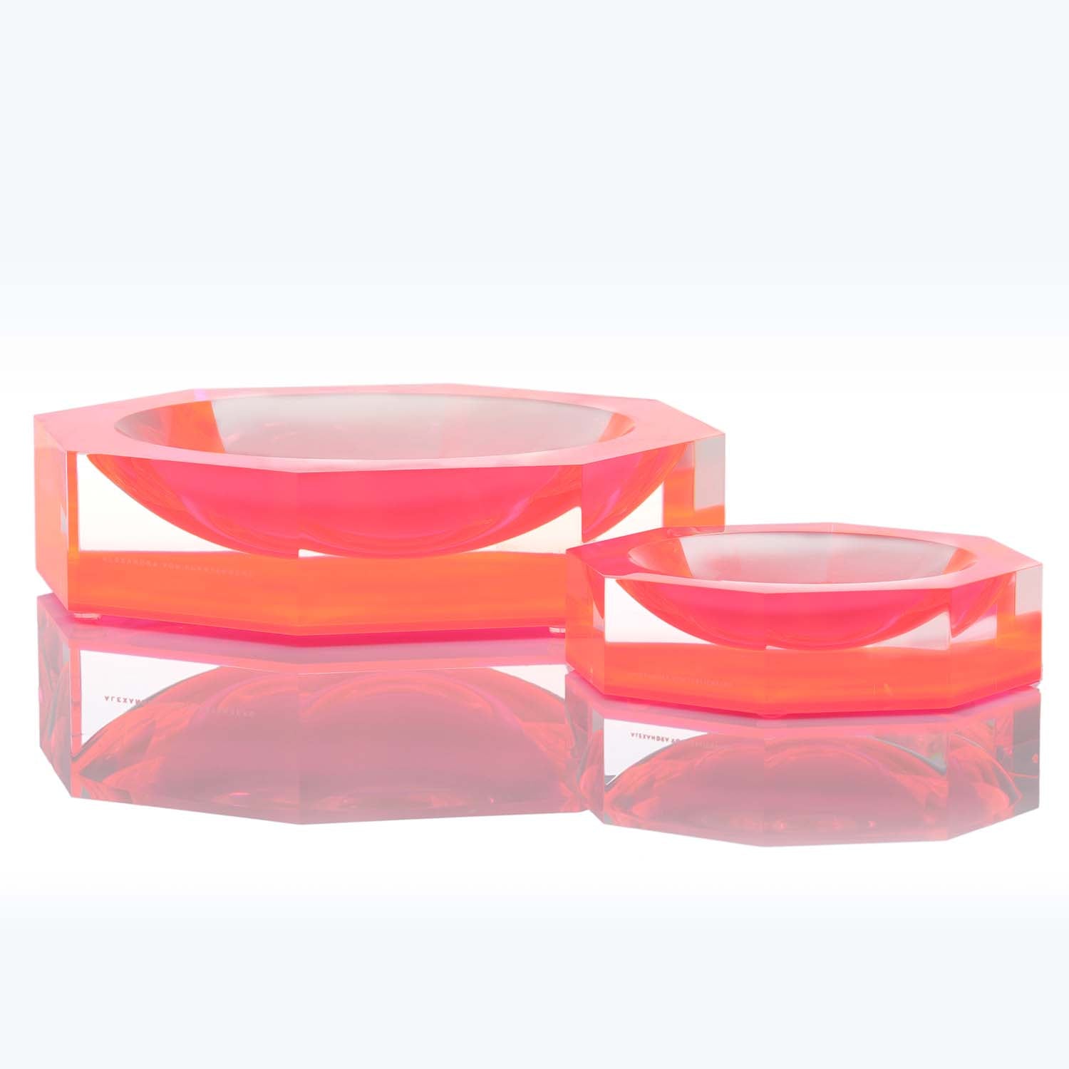 Two translucent, modern and stylish acrylic bowls in neon pink.