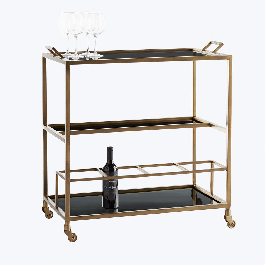 Elegant bar cart with gold frame and glass shelves.