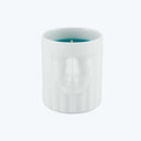 Minimalist cylindrical candle with relief sculpture of human face.