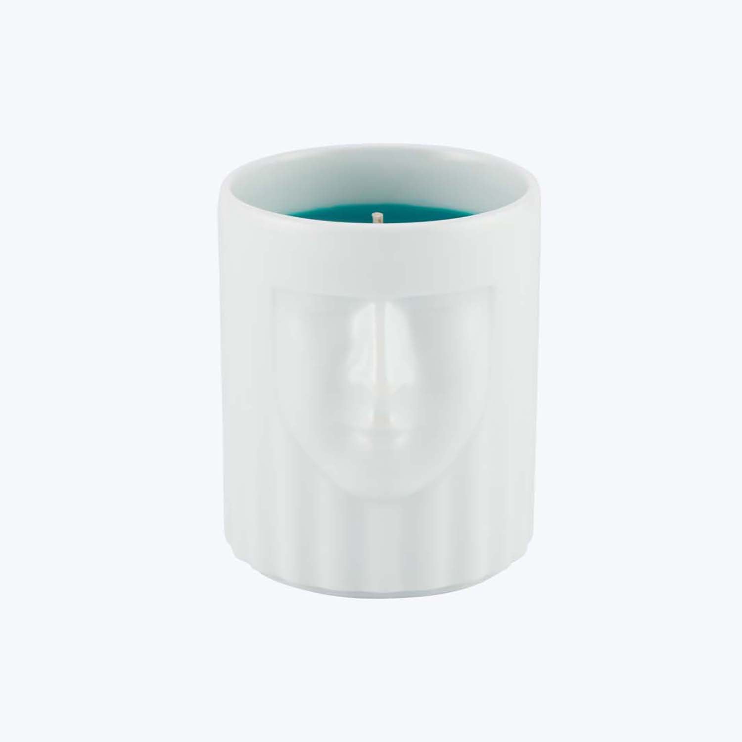 Minimalist cylindrical candle with relief sculpture of human face.